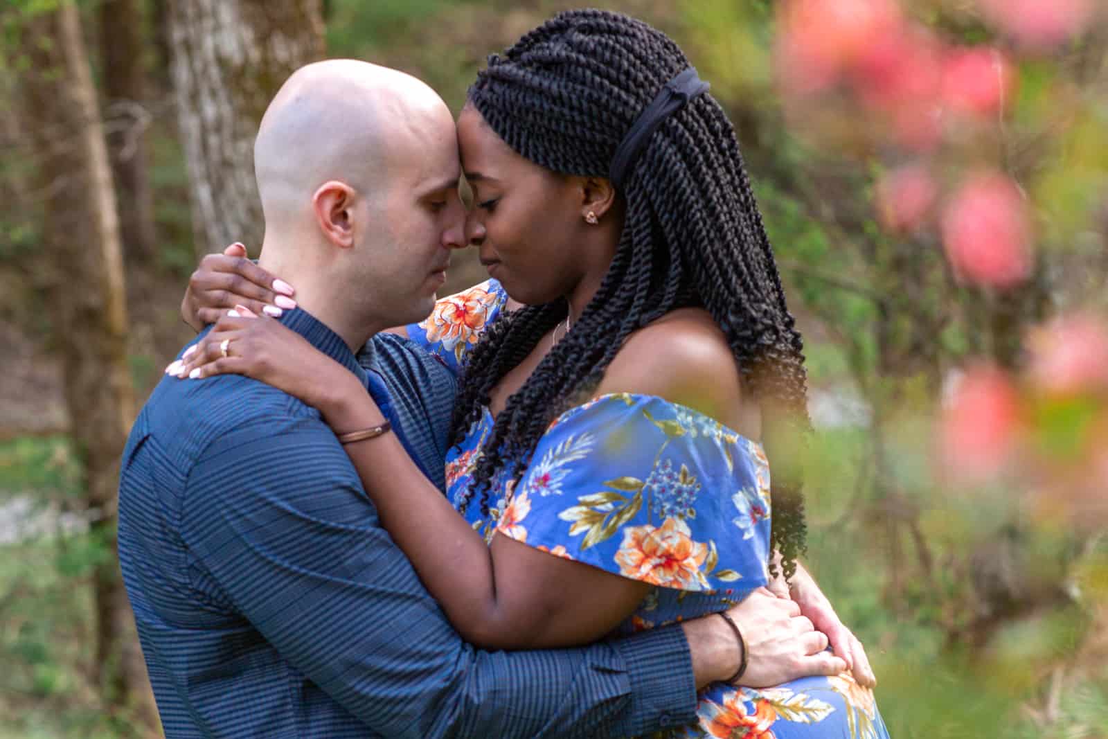 Spring Nashville Elopement at Butterfly Hollow; bride and groom embrace with foreheads together and pink flowers are blurred to frame their image